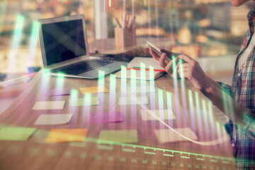 Double exposure of woman hands working on computer and forex graph hologram drawing. Financial analysis concept.