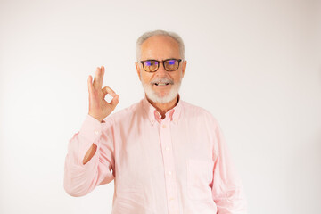 Naklejka premium happy positive handsome old man shows okay sign over white background.