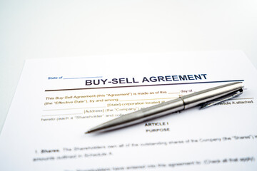 Buy and sell agreement contract closeup with pen.