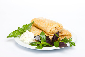 Rolled stuffed pancake on white plate 