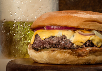 Gourmet Cheese Burger on special bread and beer on wooden table
