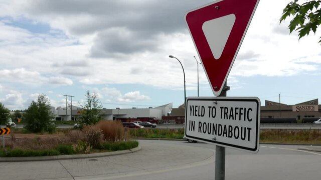 The motion of yield to traffic in roundabout sign with traffic flow background with 4k resolution.