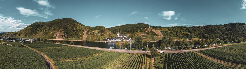 Panoramic view of the Moselle vineyards near Beilstein, Germany. Metternich Castle above the Moselle river. .Drone photography. Created from several images to create a panorama image.