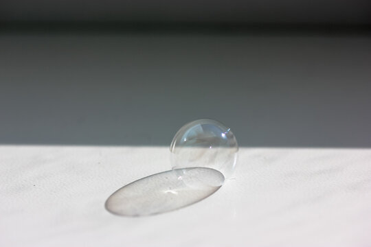 Soap Bubbles On The Surface Of White Table. View From Above, Flatly. Children's Fun. Contrasting Shadow From A Soap Bubble On Sunny Day,