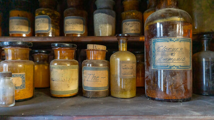 A bottle of poison on a background of old medical, chemistry and pharmacy glass. Chemistry and pharmacy history panoramic concept background.