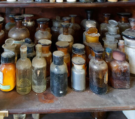 A bottle of poison on a background of old medical, chemistry and pharmacy glass. Chemistry and pharmacy history panoramic concept background.