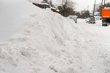 Snow heaps along the road during snowfall