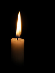 One candle flame at night closeup.