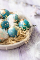 Blue Easter eggs on purple wooden table background