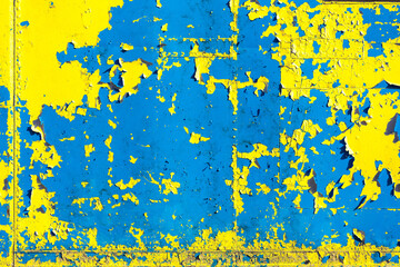 Old blue metal wall background texture with yellow paint peeling off
