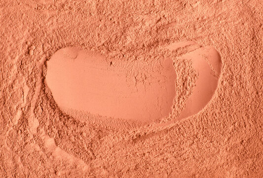 Red terracotta bentonite clay powder. Natural beauty treatment and spa. Clay texture close up, selective focus. Abstract background.