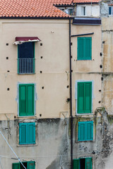 Fototapeta na wymiar old house facade with green wooden shutters in calabria