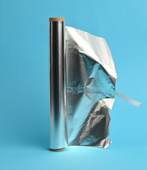 unwrapped roll of gray foil on a blue background