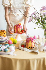 Easter table setting. Easter cake craffin. Woman on background