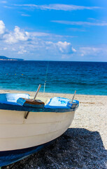 Fototapeta na wymiar white and blue boat on beach with blue sky and mediterranean sea