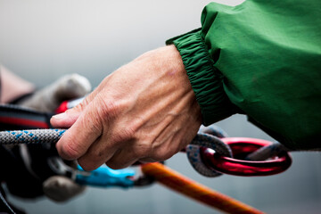 close up of a mans hand tying rope