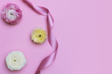 Flowers and pink ribbon on the pink background. Copyspace background.