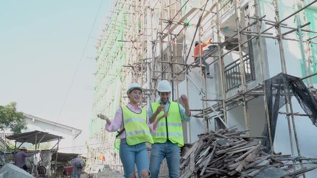 eam of young caucasian man contractor, woman engineering walk together, take off them safety helmet, handshake after finish inspect, defect of building, apartment. Engineer,architect worker concept.