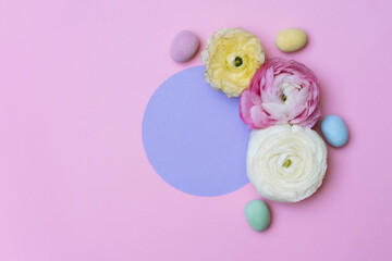 Flowers, easter eggs and purple circle on the pink background. Copyspace background.