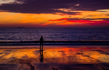 Fototapeta na wymiar Woman enjoying the sunset at fuente bravia beach in el puerto de santa maria cadiz 