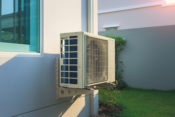 Condenser unit or compressor outside home or residential building. Unit of central air conditioner...