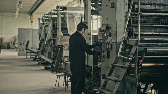 STACK OF FOOTAGE: Worker presses buttons on the control panel in olg abandoned printing house. USSR, GDR