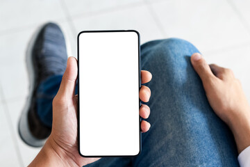 mockup copy space phone, man's hand holding smartphone with blank white copy screen for your advertising and message or information content, mobile on desk at coffee shop.