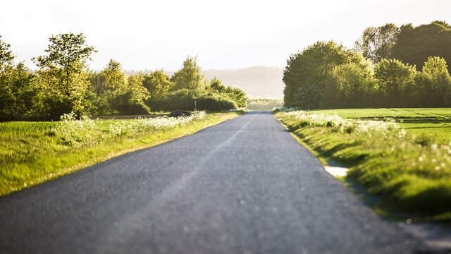 a long road on a beautiful field in summer