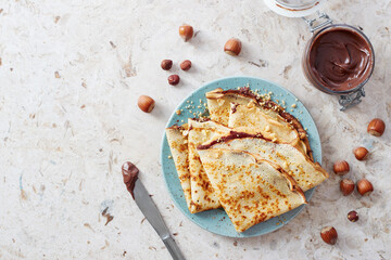 Homemade crepes, tasty thin pancakes with chocolate and nuts.