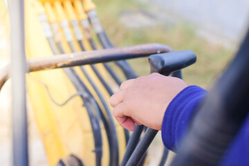A man hand is controlling a backhoe.