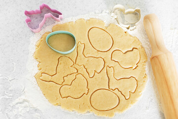 Dough with cookie cutters and rolling pin on kitchen table