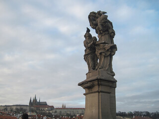 Fototapeta na wymiar Religious stone sculptures of the Charles Bridge in Prague on a cloudy day.