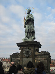 Fototapeta na wymiar Religious stone sculptures of the Charles Bridge in Prague on a cloudy day.