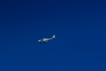 The plane flies in the blue sky