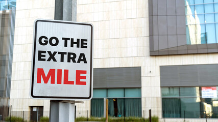 Go the extra mile sign in a downtown city setting