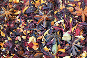 Texture of dry herbal tea with spices and fruits (hibiscus, star anise and other). Soft focus around the edges of the image