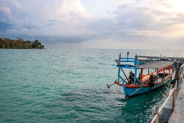 an asian adult standing on his fishing boat to start work day on morning at the island driving for people as a taxi