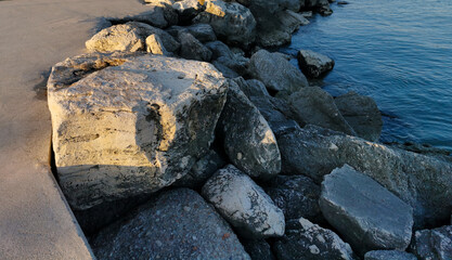 Scogli illuminati dal sole sul mare calmo e azzurro