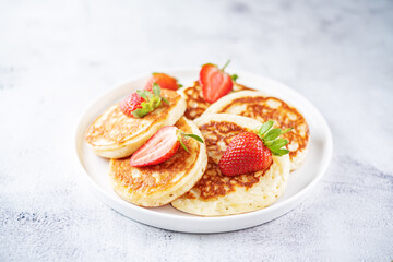 Pancakes decorated with strawberries in a plate