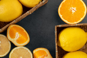 Fresh lemon and fresh orange on the dark stone table, healthy drink, top view, copy space.