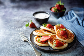Pancakes decorated with strawberries in a plate