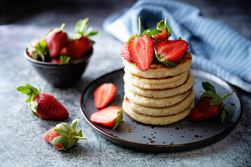 Pancakes decorated with strawberries in a plate