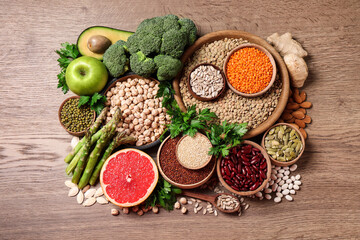 Fresh vegetables, fruits and seeds on wooden table, flat lay