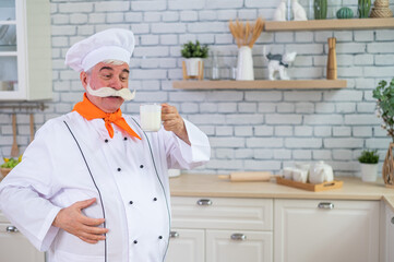 A friendly elderly milkman with a glass of milk. Portrait of a male farmer with a bushy mustache.