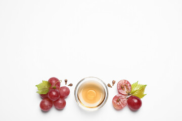 Composition with bowl of natural grape seed oil on white background, top view. Organic cosmetic