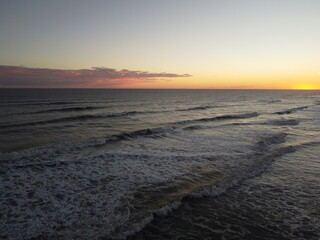 sunset in the atlantic ocean coast of argentina monte hermoso. waves with foam and beautiful sky colors