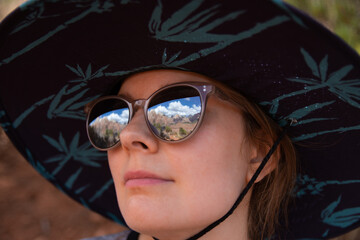 Close-up portrait of girl with glasses reflecting Zion National Park mountains