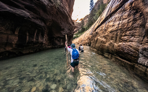 Wide shot of people going in river basin to narrow canyon's gap in Zion national park in Utah, america