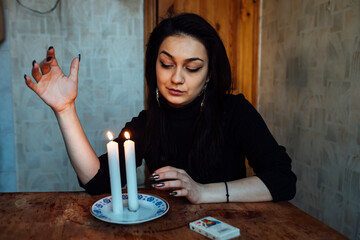 the girl is guessing on a lighted candle and cards, predicting the future and fate