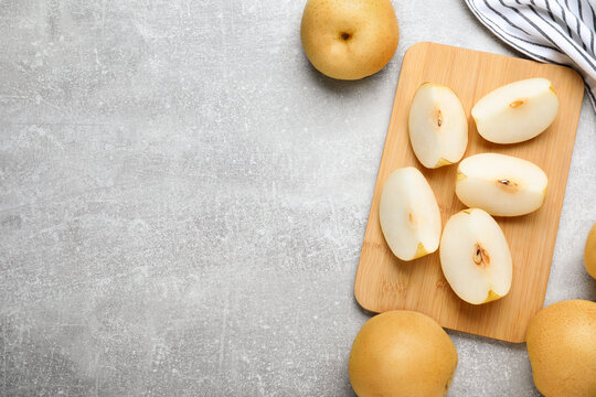 Cut and whole apple pears on grey table, flat lay. Space for text